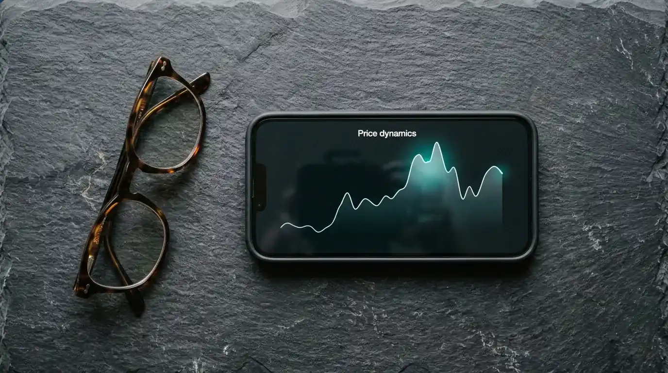 Smartphone con app de monedero electrónico y gráfico de volatilidad de criptomonedas sobre una mesa oscura